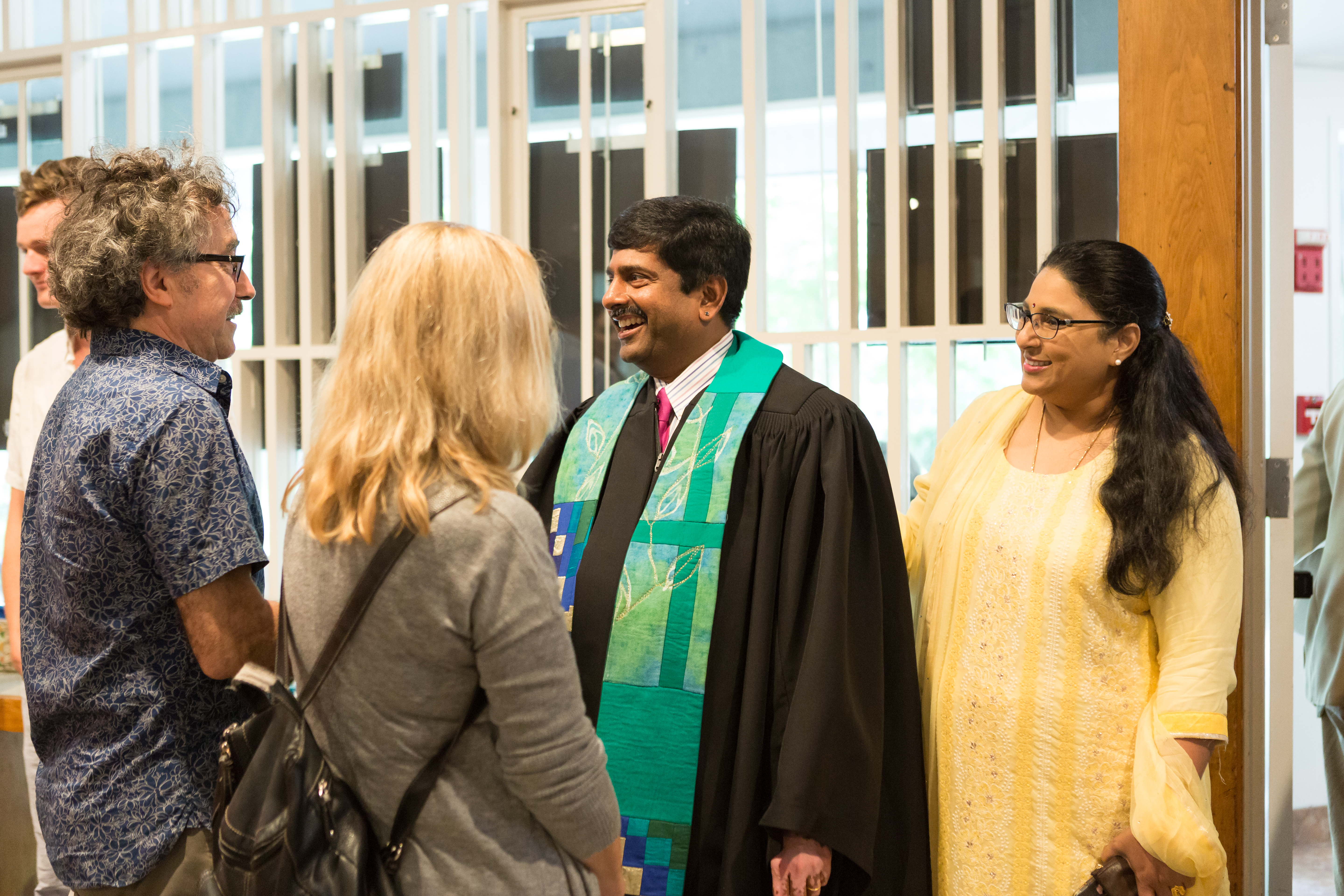 photo of Rev. Abhi and his wife in the welcoming line to greet congregants after worship on a Sunday
