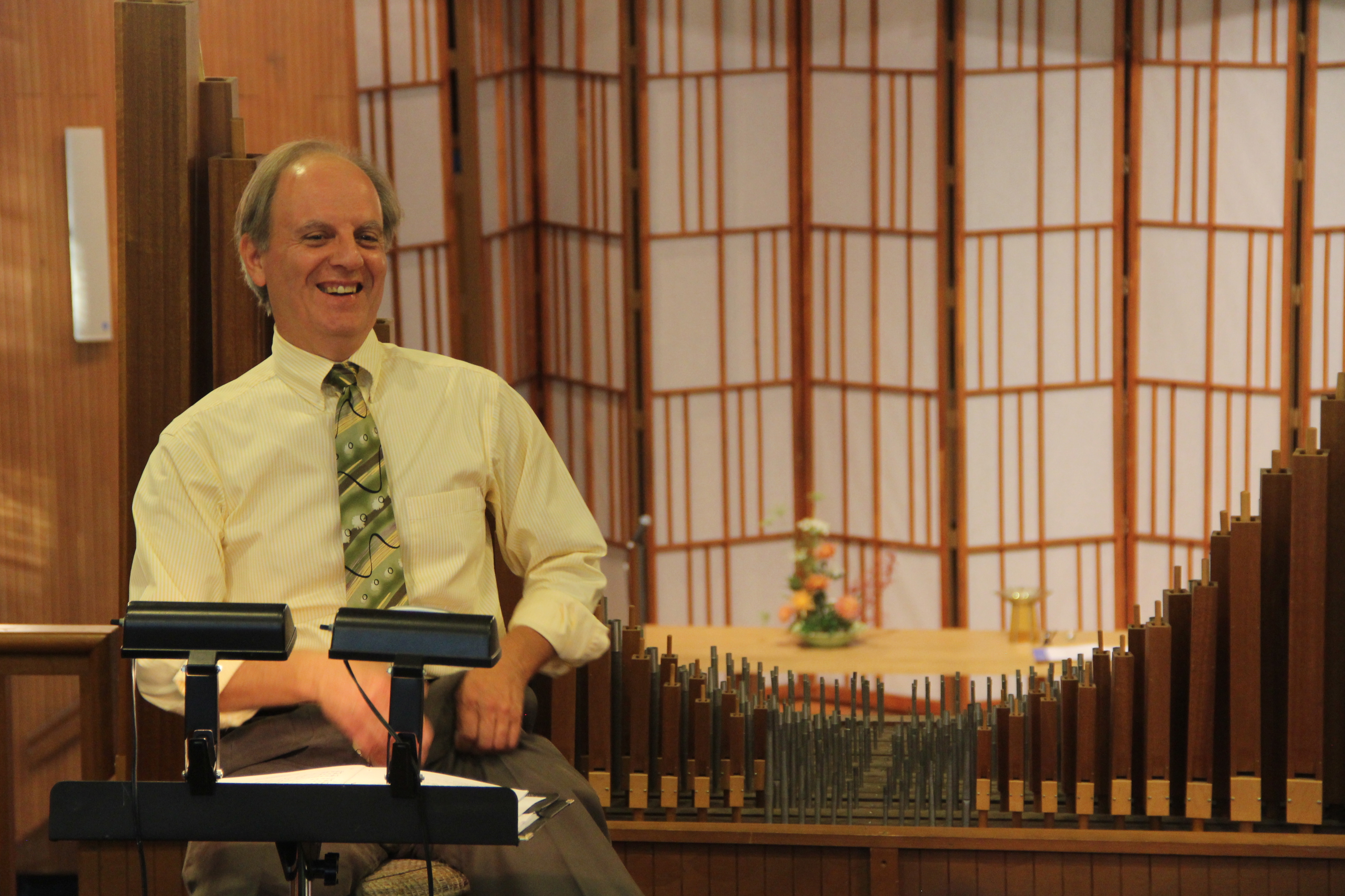 Dr. Henry Sgrecci laughing in the Choir Loft in front of a music stand