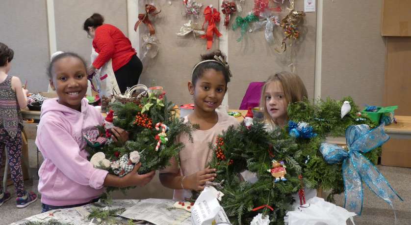 young girls with wreaths they made during Holiday Craft Day